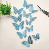 A set of twelve blue and black 3D butterfly wall stickers scattered on a white background.