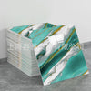 A stack of faux marble 3D self-adhesive wall tiles featuring teal and white marble patterns with gold veining.