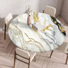 A round marble print tablecloth with gold veining is displayed on a wooden table surrounded by modern chairs.
