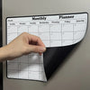 A hand points to a monthly planner calendar displayed on a refrigerator, showing days of the week.
