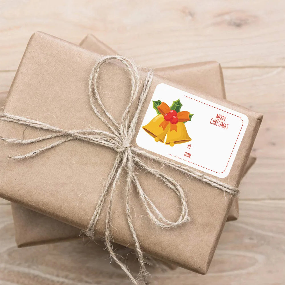 A brown gift wrapped with twine and featuring a yellow bell sticker with a red bow and the text Merry Christmas