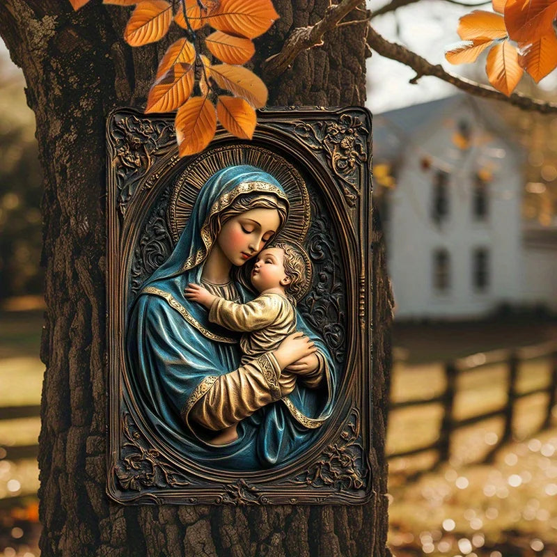 A metal sign depicting the Virgin Mary holding the infant Jesus, mounted on a tree trunk.