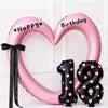 Pink heart-shaped balloon decoration with Happy Birthday text and a black number 1 and 8