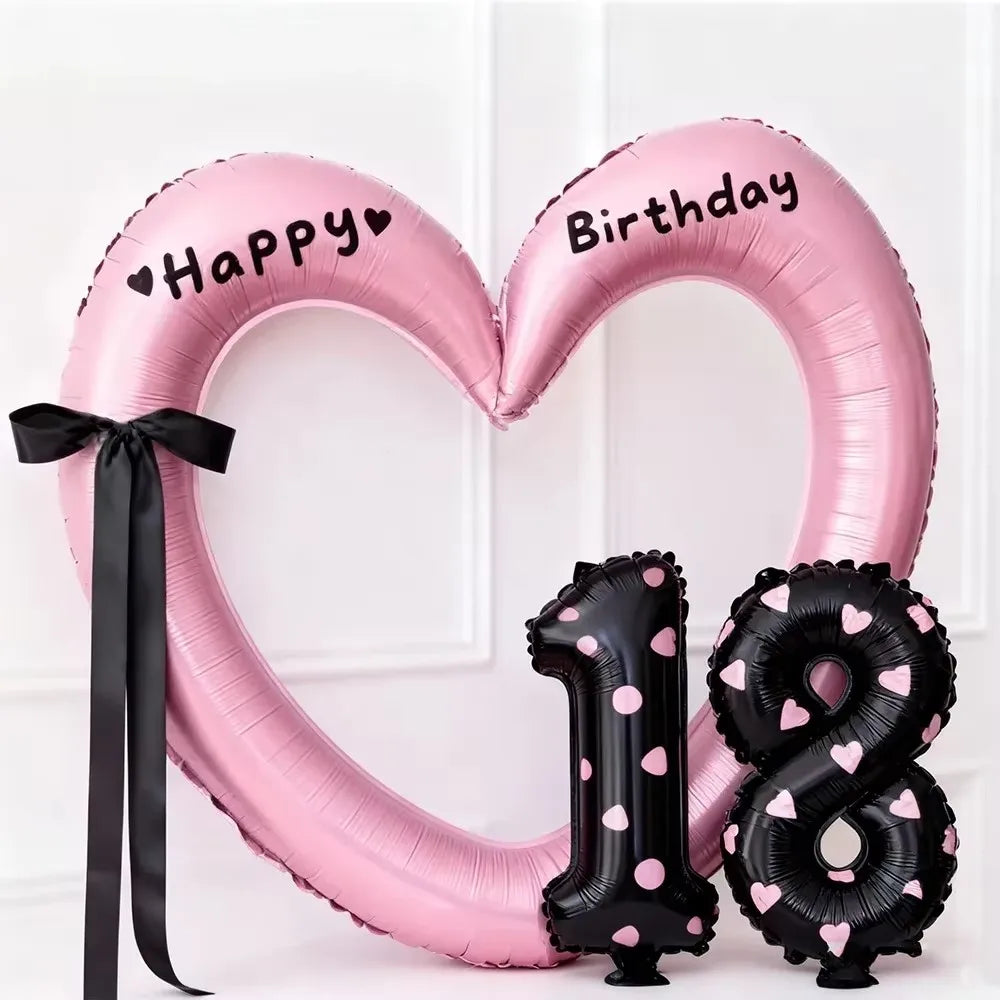 Pink heart-shaped balloon decoration with Happy Birthday text and a black number 1 and 8