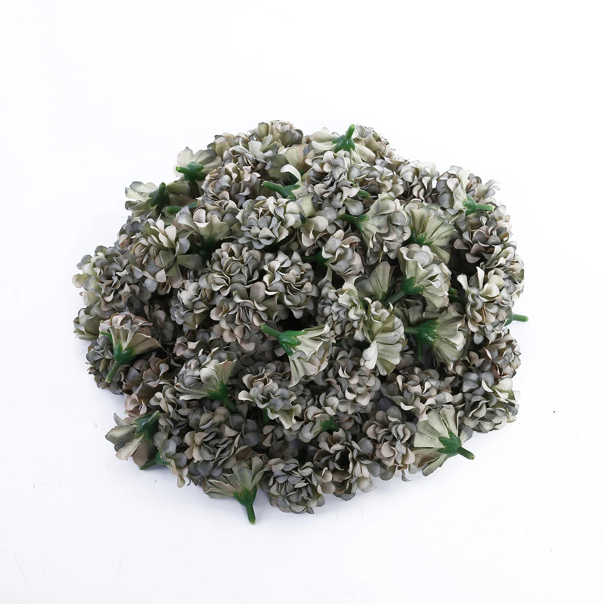 Une pile de têtes de fleurs artificielles mini hydrangeas dans des tons de vert et de gris.