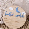 A wooden birth announcement sign with the words hello world and blank lines for name date time weight and length, decorated w