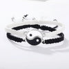 A set of braided bracelets featuring black and white Yin-Yang designs on white and black cord.