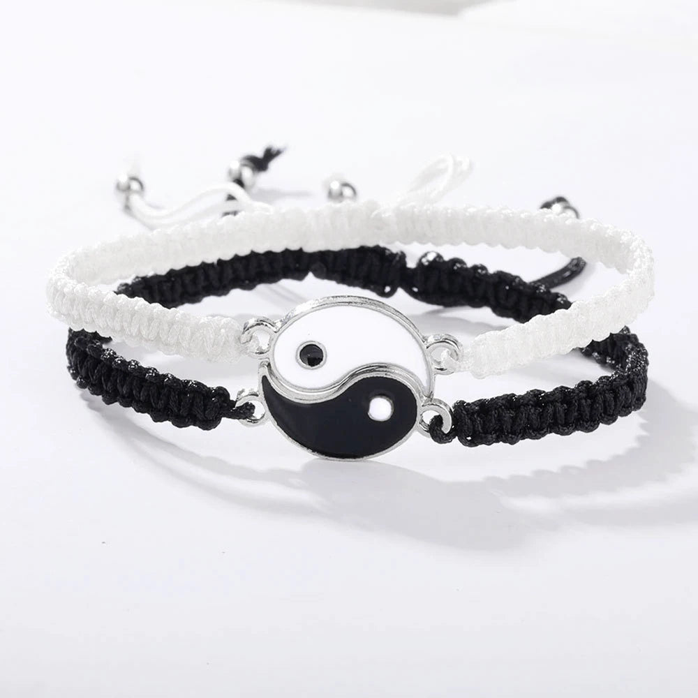 A set of braided bracelets featuring black and white Yin-Yang designs on white and black cord.