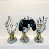 A set of three hand-shaped metal organizers for storing 3D gamepads and controllers.