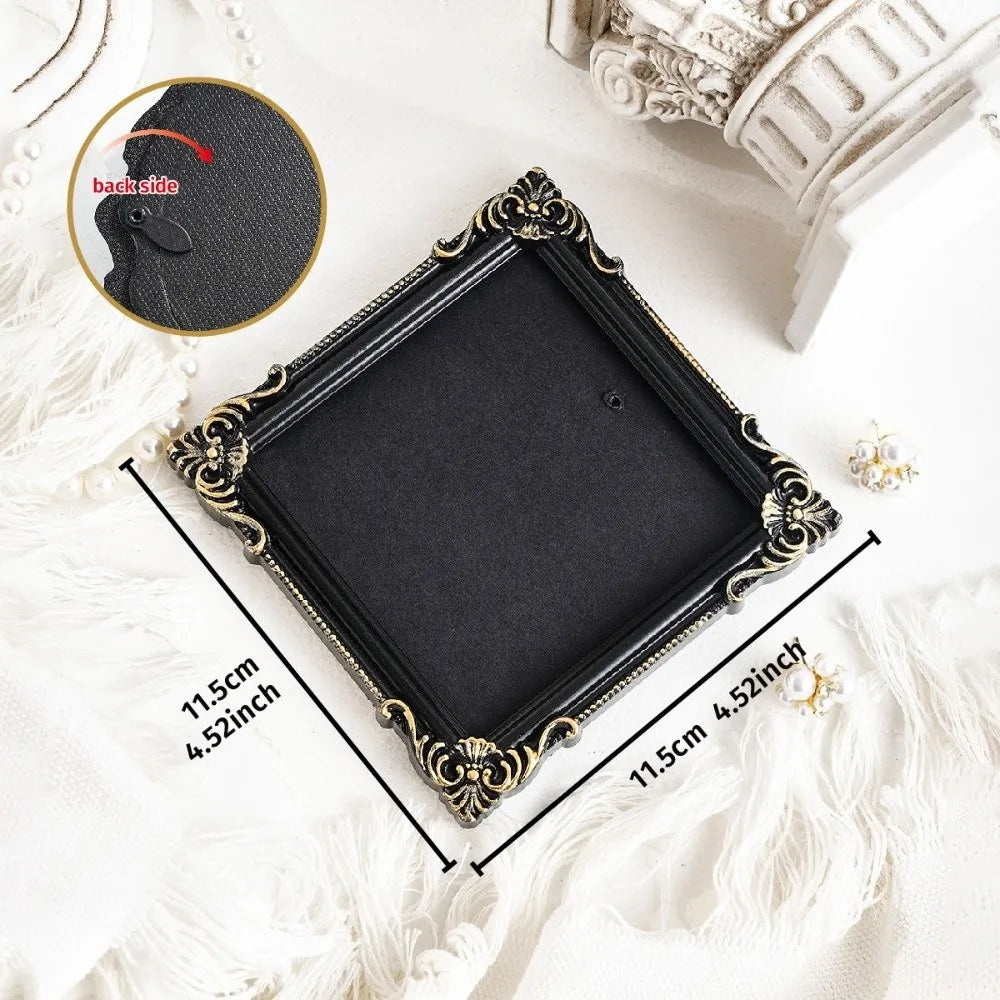 A black vintage baroque resin hanging photo frame displayed on white fabric with a detail inset.