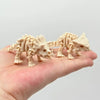 A light beige 3D printed dinosaur skeleton model is held in a person's hand.