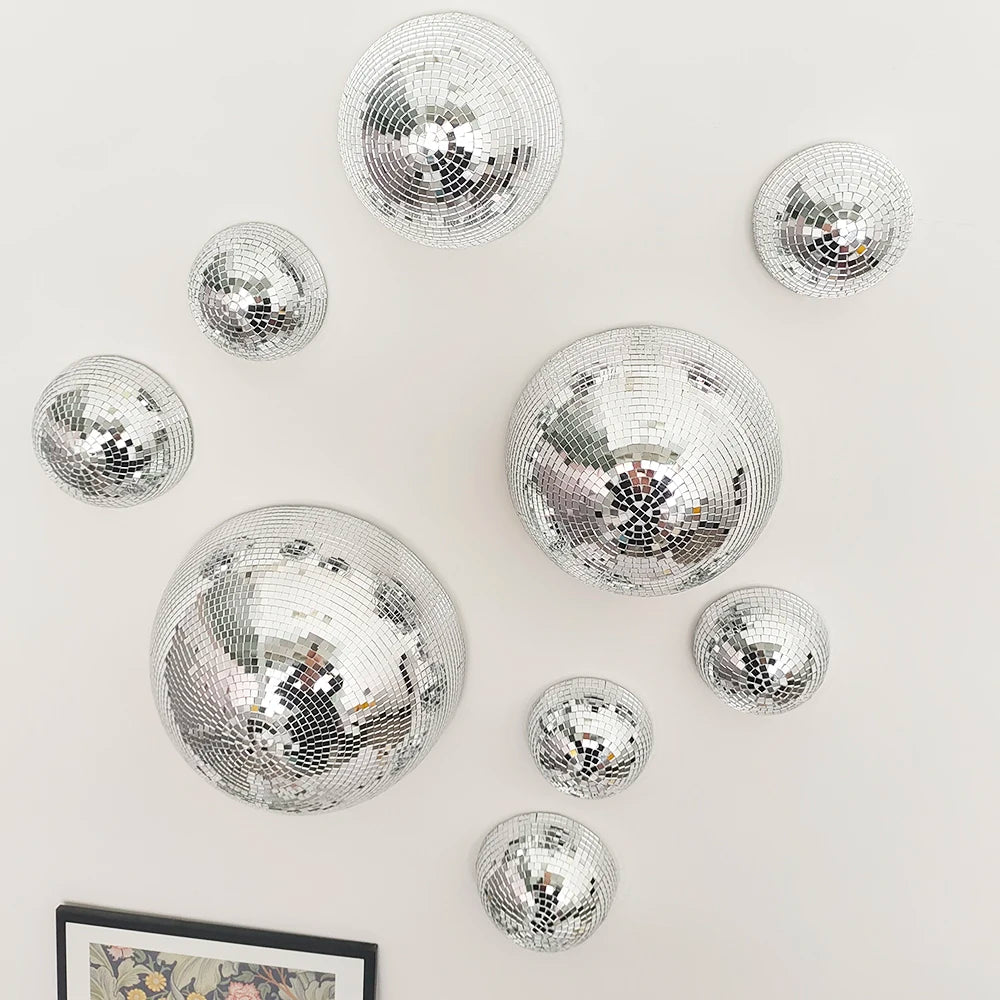 A collection of silver disco balls and a framed picture arranged on a white surface.