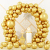An archway made of metallic gold balloons decorated with white flowers for party or event use.
