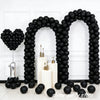A black balloon archway decorated with black latex balloons and white candles.