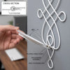 A hand demonstrates the folding hinge point and pin & barrel assembly of a white decorative iron wall candle sconce set.