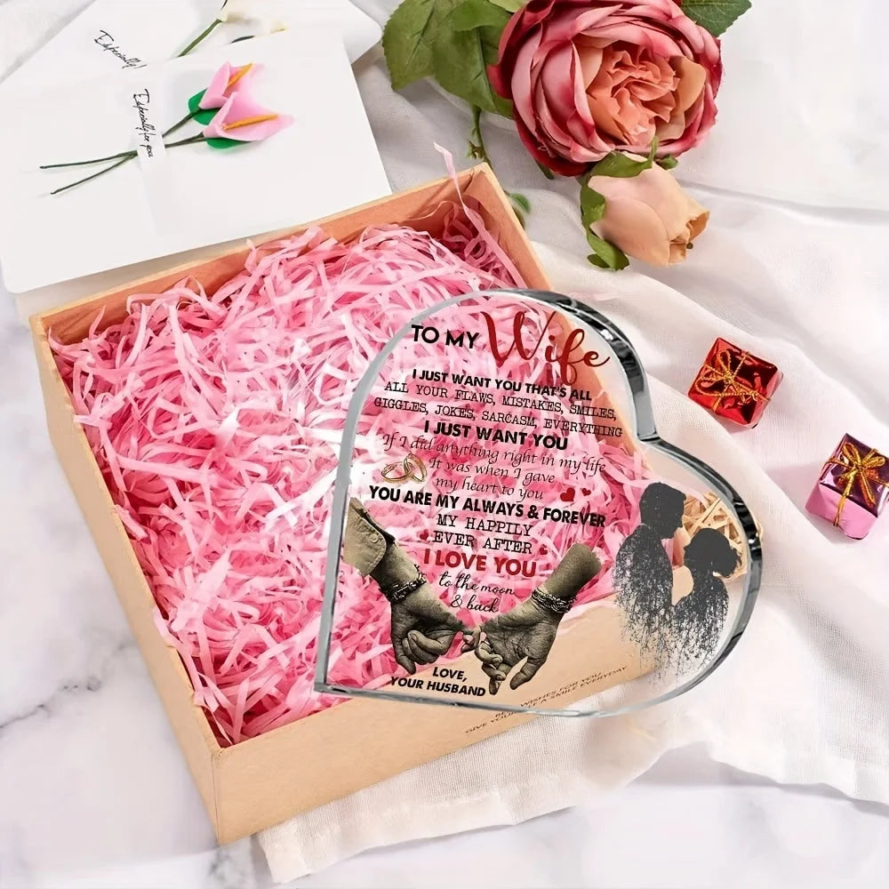 A heart-shaped acrylic decoration featuring a couple silhouette and text, presented in a wooden box with pink shredded paper.