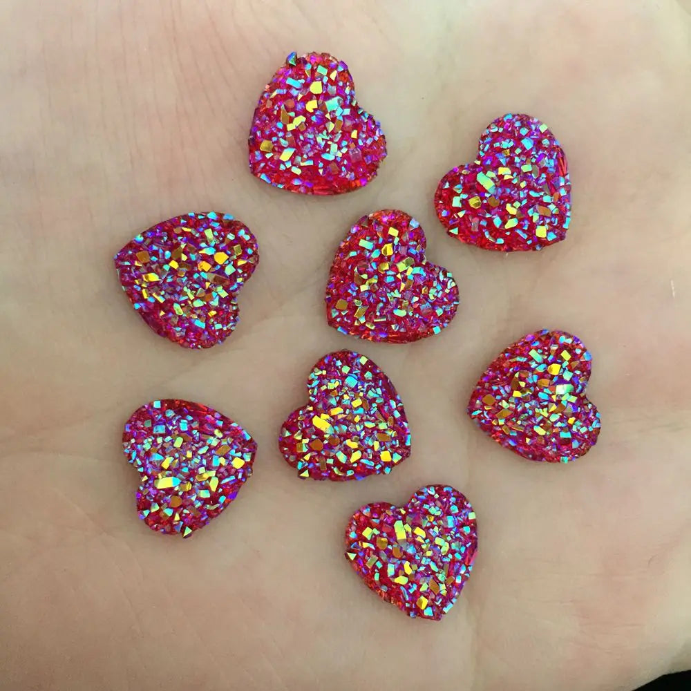 Eine Sammlung kleiner, herzförmiger Ornamente, bedeckt mit glitzernden rosa und goldenen Pailletten.