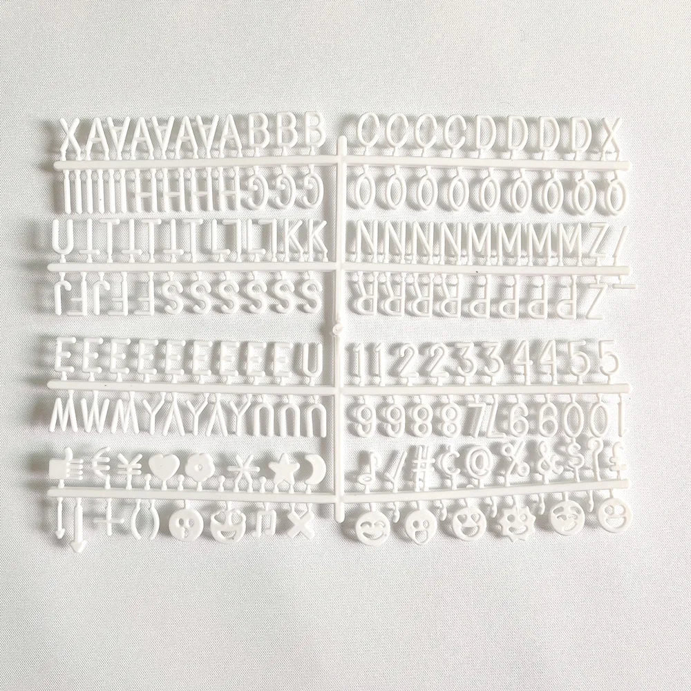 A white wooden message board with various letters and symbols carved into it.