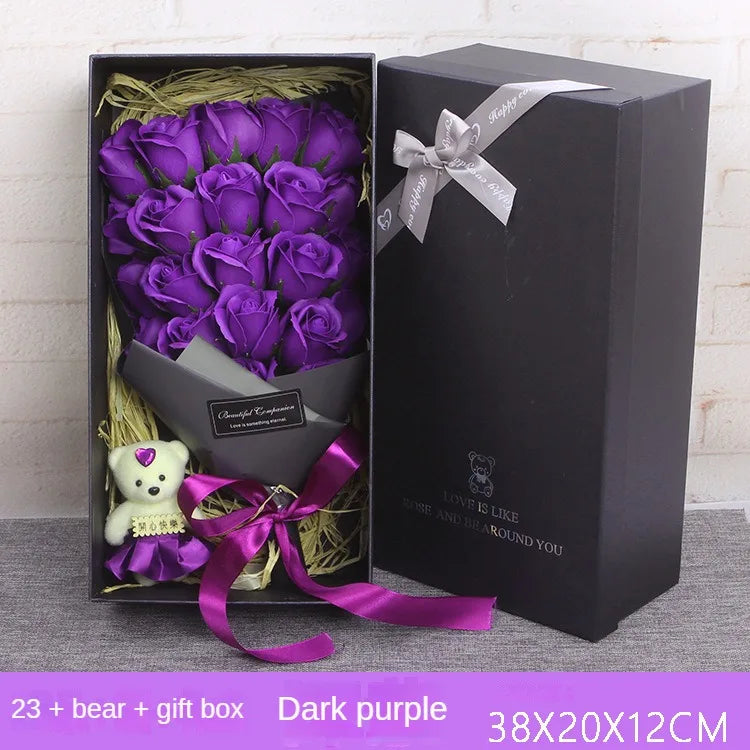A gift box containing a bouquet of dark purple roses and a small teddy bear