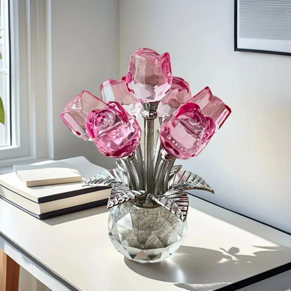 A glass vase filled with pink crystal rose-shaped decorative flowers on a white table.