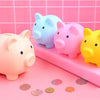 A collection of pink, blue, and yellow pig-shaped coin storage banks arranged on a pink tray.