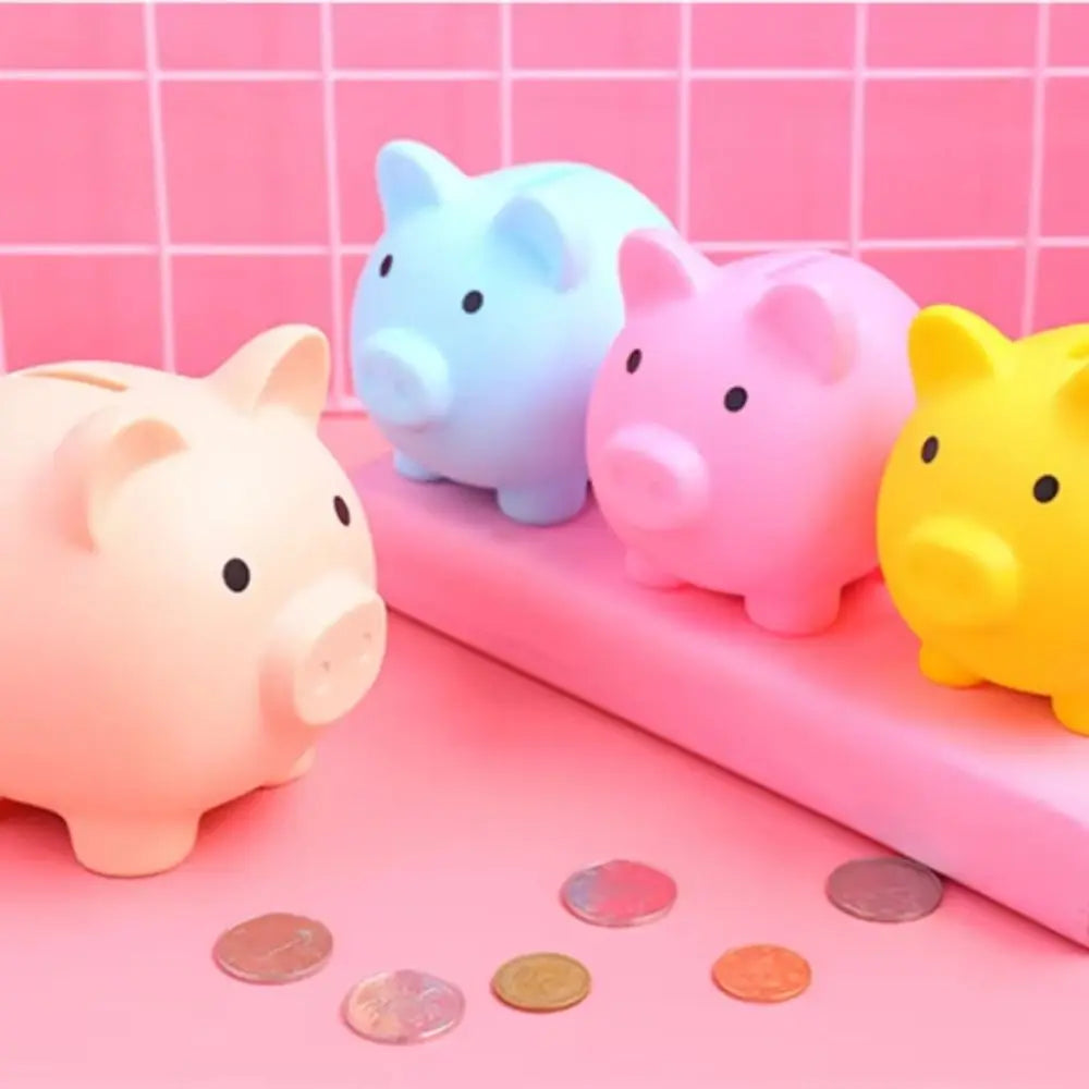 A collection of pink, blue, and yellow pig-shaped coin storage banks arranged on a pink tray.