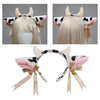 A headband featuring cow ears with black and white patches, adorned with bells and ribbon bows.