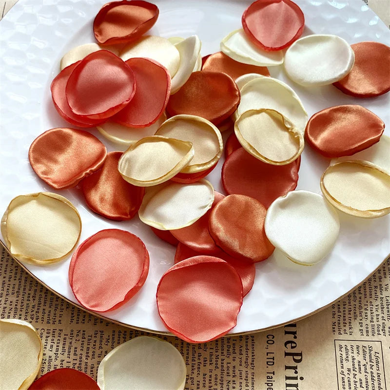 A collection of rose-colored and white silk petals arranged on a white plate.