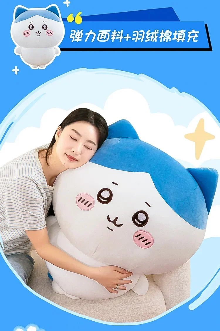 A soft white and blue Usagi Chiikawa plush doll is being cuddled by a woman in a light striped shirt.