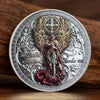 A commemorative coin featuring Saint Michael the Archangel with wings and a sword, set against a decorative border.
