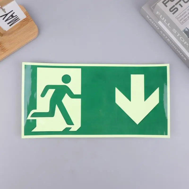 A green photoluminescent emergency exit sign decal showing a silhouette of a person walking and a downward arrow.