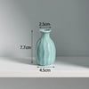 A light blue ceramic mini vase with a rounded body and narrow neck, shown against a white background.