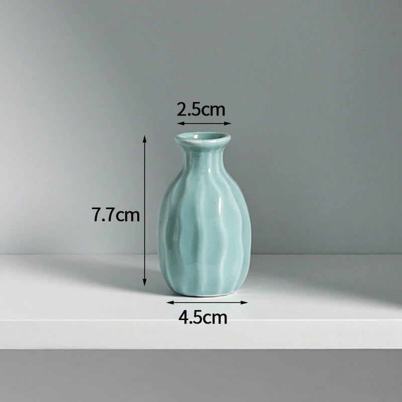 A light blue ceramic mini vase with a rounded body and narrow neck, shown against a white background.