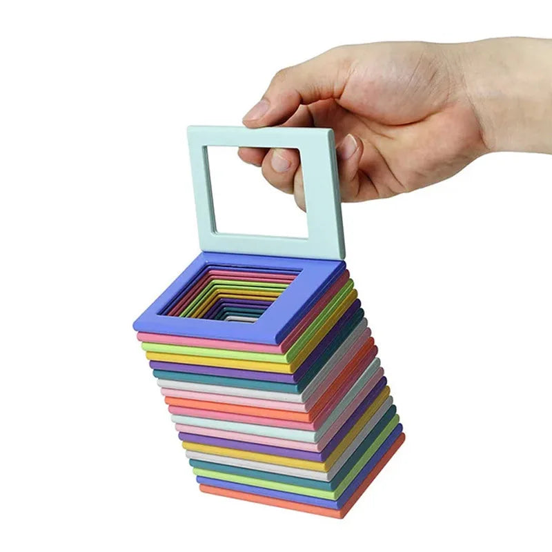 A hand holds a light blue magnetic photo frame with a stack of colorful magnetic frames below it.