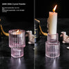 Porta candela de vidrio transparente con base texturizada rosa y vela encendida.