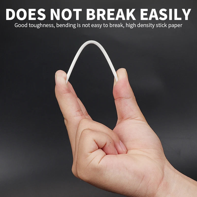 A hand is holding a white lollipop stick, demonstrating its toughness and bending resistance.