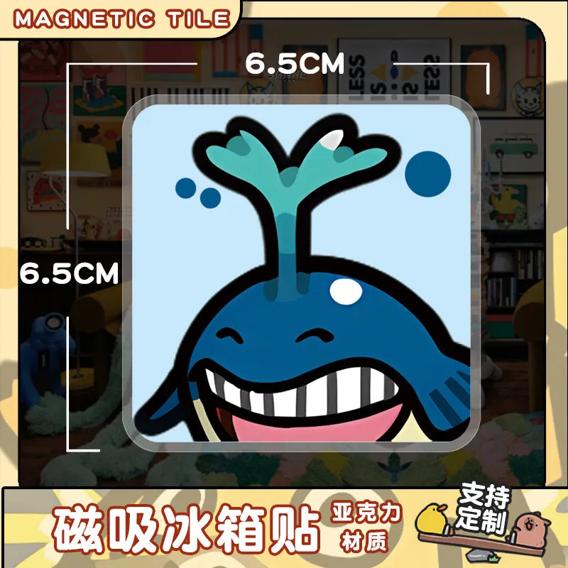 A blue and white acrylic fridge magnet featuring a stylized, smiling sea creature.
