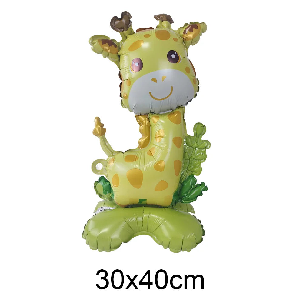 A foil balloon shaped like a smiling yellow giraffe with brown accents and green foliage.