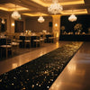 Elegant white sparkling aisle runner leading down a polished hall with chandeliers and dark decor.