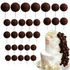 A set of dark chocolate spherical cake toppers on sticks arranged in rows.
