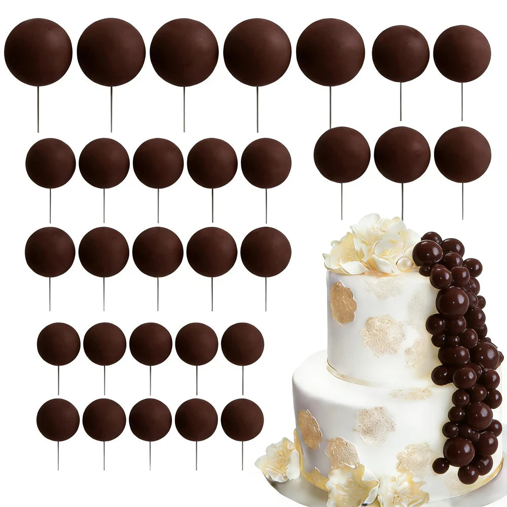 A set of dark chocolate spherical cake toppers on sticks arranged in rows.