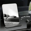 A foldable vanity mirror with an adjustable stand is shown on a dark surface, displaying a reflection.
