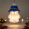 A blue camping ghost night light hangs, featuring a hooded shape with a warm flickering glow.