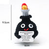 Black crochet potato doll with a red and yellow hat and an inspirational support card
