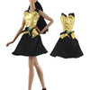 A handmade doll dress gown featuring a black skirt and gold bodice with green accents.