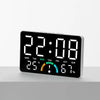 A digital alarm clock displaying 22:08, temperature, and humidity percentage on a white surface.