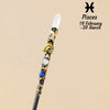 A natural clear quartz zodiac crystal wand with gold accents and a blue stone, displayed against a beige background.