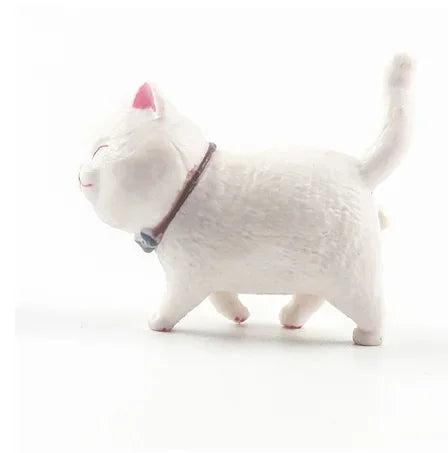 A white 3D cartoon cat figurine used as a refrigerator magnet.