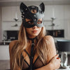 A woman wearing an elegant black fox masquerade mask with a strap, looking directly at the camera.