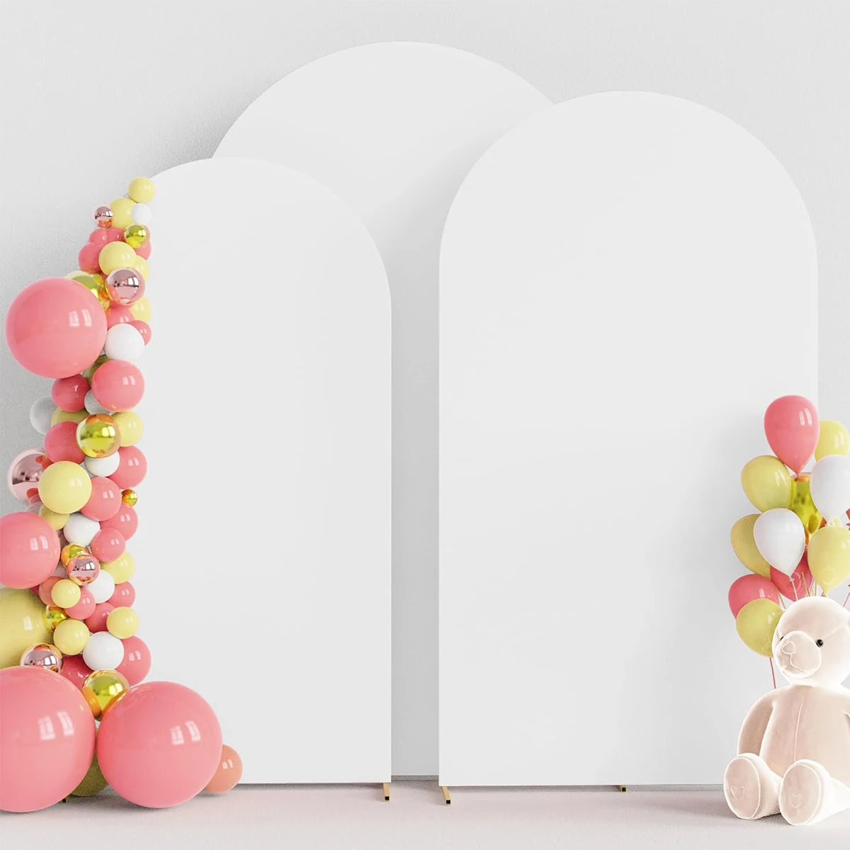 A white wedding arch cover decorated with pink and yellow balloons and a pink teddy bear.